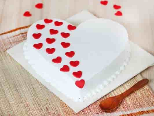 Heart cake for St. Valentine's Day, Mother's Day, or Birthday, decorated  with roses and pink sugar hearts on wooden table Stock Photo - Alamy