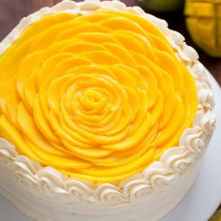 A beautifully decorated Mango Flower Cake with mango-flavored layers and floral designs, perfect for tropical-themed celebrations and special occasions.