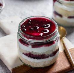 Set of six glass jars filled with layers of blueberry dream cake, perfect for satisfying your sweet cravings.