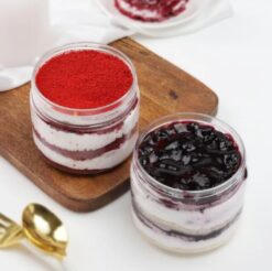 Glass jars filled with layers of blueberry and red velvet cakes, a delicious combination for dessert lovers.