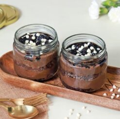 Set of six glass jars filled with layers of heavenly chocolate truffle cake, a luxurious treat for chocolate enthusiasts.