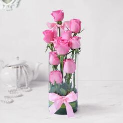 A vase filled with a stunning arrangement of ten pink roses, adding elegance and beauty to any space.