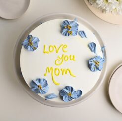A beautifully frosted cake adorned with delicate flowers, a perfect treat to celebrate Mom on Mother's Day.