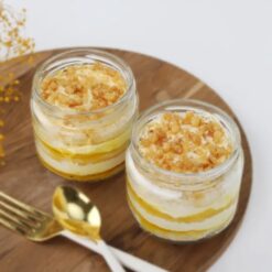Two glass jars filled with layers of butterscotch crunch cake, perfect for satisfying your sweet tooth.