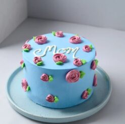 A beautifully decorated cake adorned with intricate blue floral designs, perfect for celebrating Mom's special occasion.