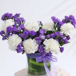 Exquisite bouquet of assorted flowers including roses and carnations, arranged beautifully in a vase.