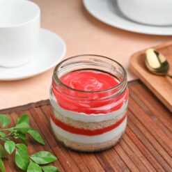 A single jar filled with layers of strawberry cake, a delicious treat for satisfying your sweet cravings.