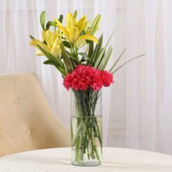 Vase arrangement featuring carnations and lilies, adding grace and beauty to any space or occasion.