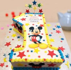 First birthday celebration cream cake with colorful decorations and candles, perfect for special occasions and parties.