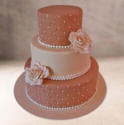 Exquisite pearl-rose three-tier cake with elegant decorations, ideal for weddings and celebrations